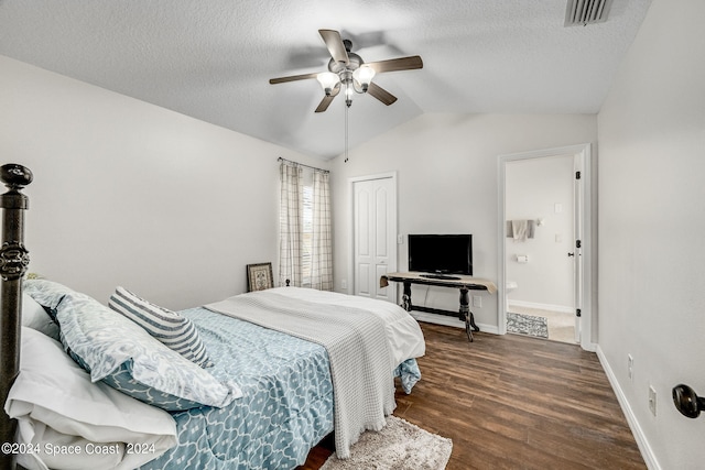 bedroom featuring lofted ceiling, ceiling fan, a closet, dark wood-type flooring, and connected bathroom