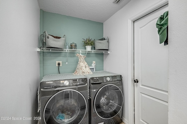 laundry area featuring separate washer and dryer and a textured ceiling