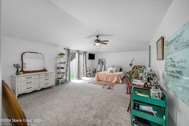 carpeted bedroom featuring ceiling fan and a textured ceiling