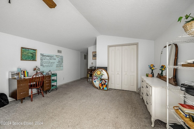 carpeted home office featuring lofted ceiling, ceiling fan, and a textured ceiling