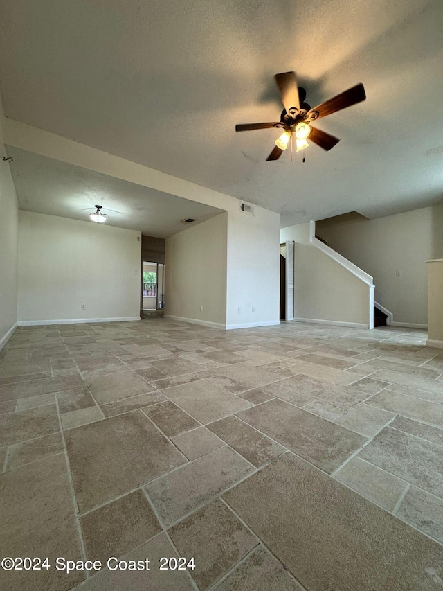 interior space with a textured ceiling and ceiling fan