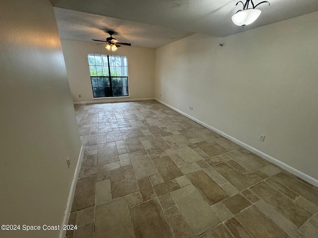 unfurnished room featuring ceiling fan and a textured ceiling