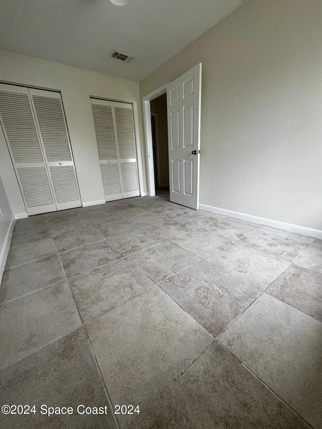 unfurnished bedroom featuring multiple closets