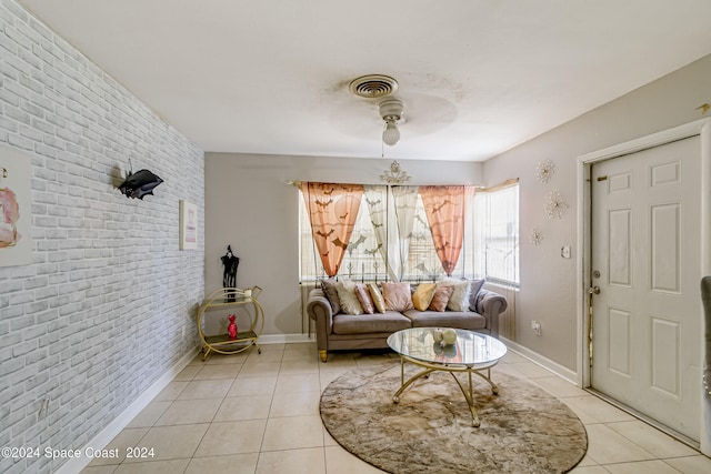 living room with brick wall, light tile patterned floors, and ceiling fan