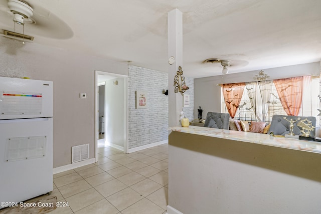 interior space with light tile patterned flooring and brick wall