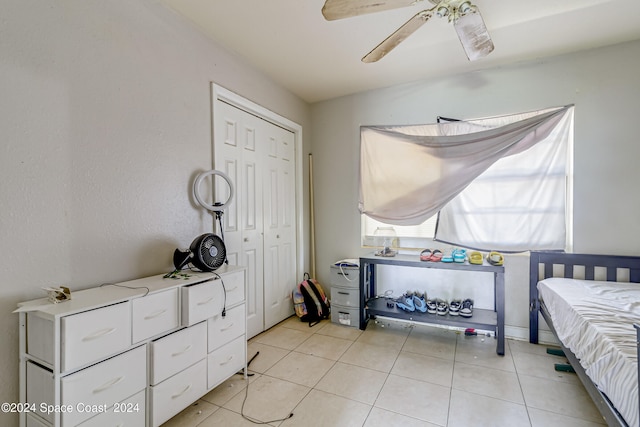 tiled bedroom with ceiling fan and a closet