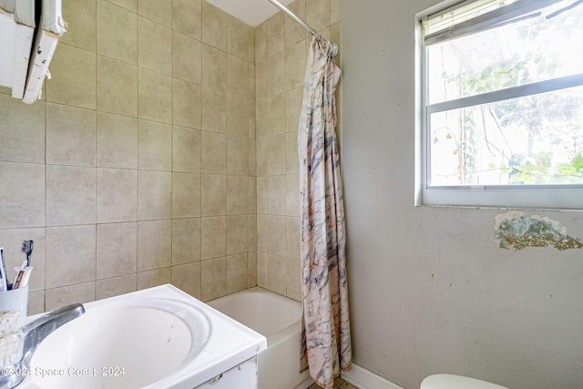 full bathroom with sink, toilet, and shower / tub combo with curtain