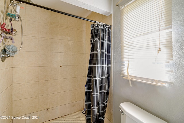 bathroom featuring a shower with curtain and toilet