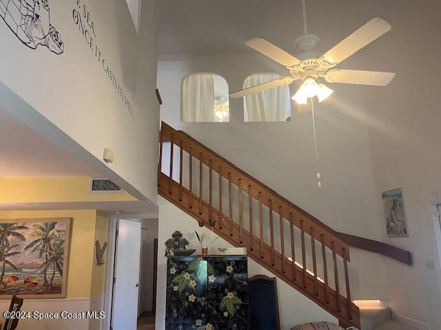 stairway with a high ceiling and ceiling fan