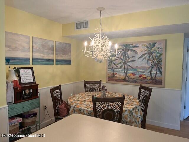 dining space with hardwood / wood-style flooring and an inviting chandelier