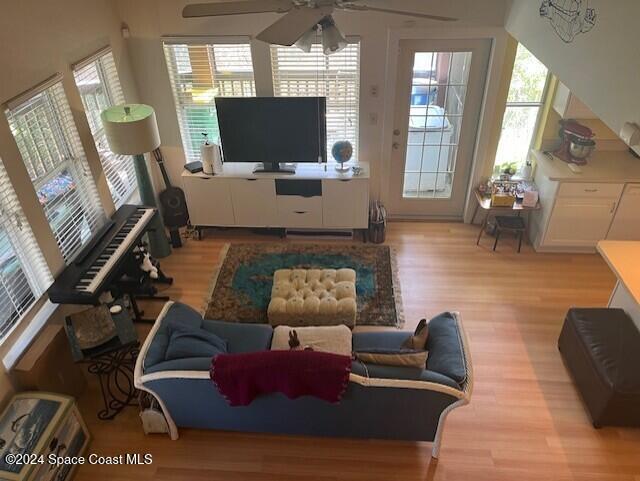 living room with light hardwood / wood-style flooring and ceiling fan