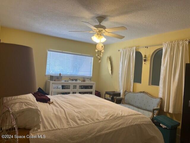 bedroom with a textured ceiling and ceiling fan