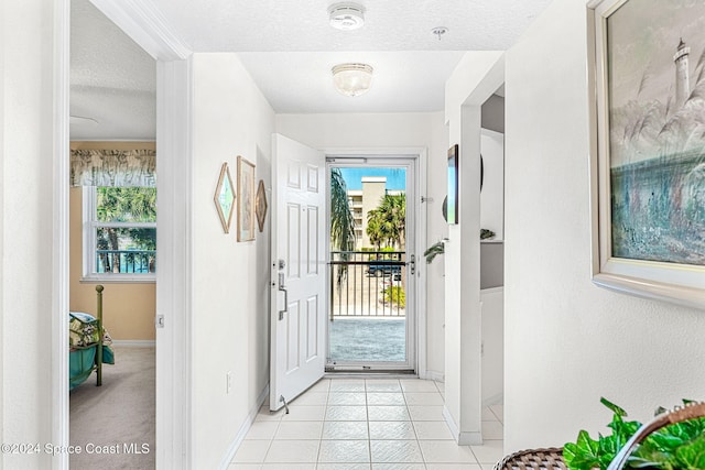 entrance foyer with a textured ceiling and light tile patterned floors