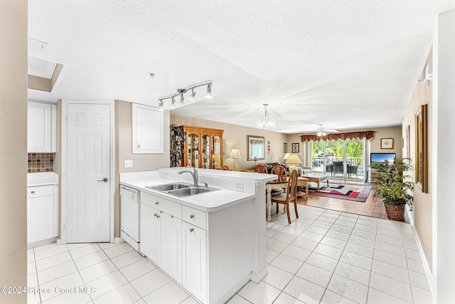 kitchen featuring kitchen peninsula, a textured ceiling, sink, and white dishwasher