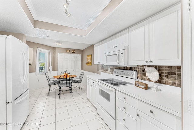 kitchen featuring white appliances, light tile patterned flooring, backsplash, a textured ceiling, and white cabinets