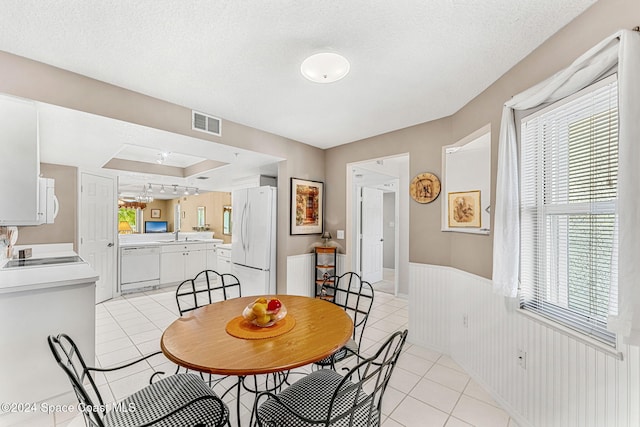 tiled dining space featuring a textured ceiling