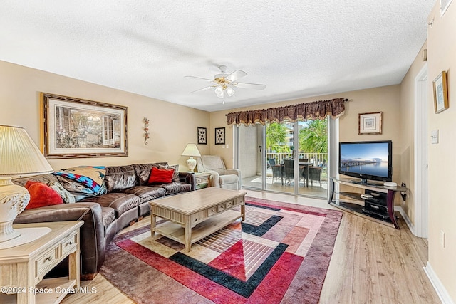 living room featuring light hardwood / wood-style floors, a textured ceiling, and ceiling fan