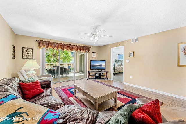 living room featuring hardwood / wood-style floors, a textured ceiling, and ceiling fan