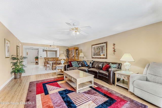 living room featuring a textured ceiling, wood-type flooring, and ceiling fan