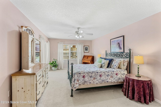 carpeted bedroom featuring a textured ceiling and ceiling fan