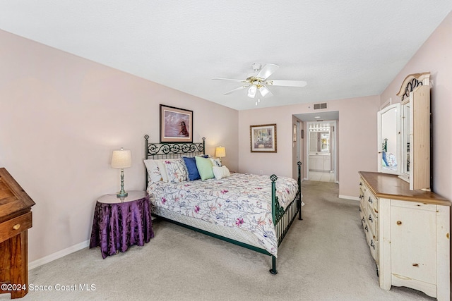 bedroom featuring ceiling fan, a textured ceiling, and light colored carpet