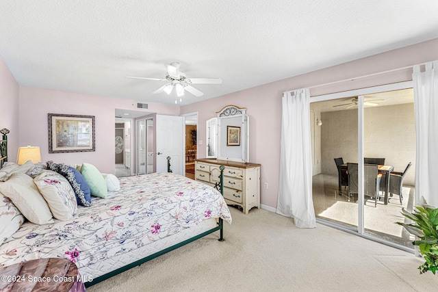 bedroom featuring access to outside, a textured ceiling, light colored carpet, and ceiling fan