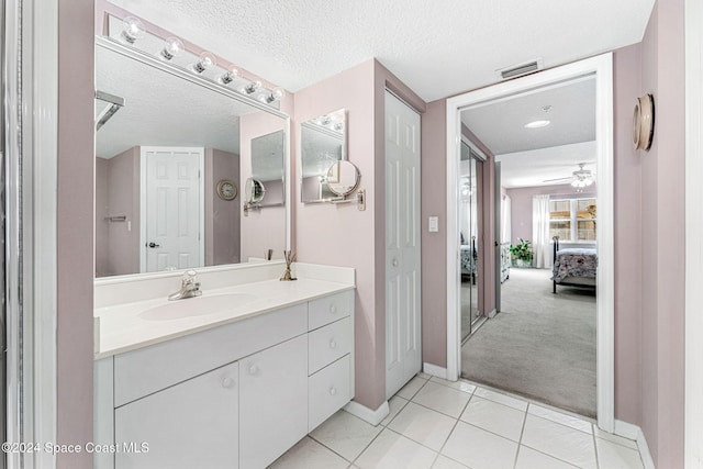 bathroom featuring vanity, a textured ceiling, ceiling fan, and tile patterned flooring