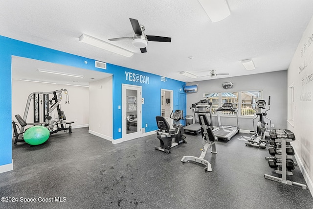 gym featuring a textured ceiling and ceiling fan