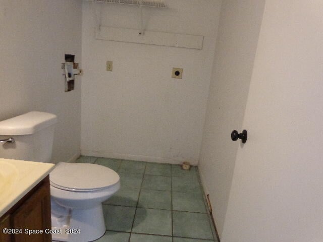 bathroom featuring toilet, tile patterned flooring, and vanity