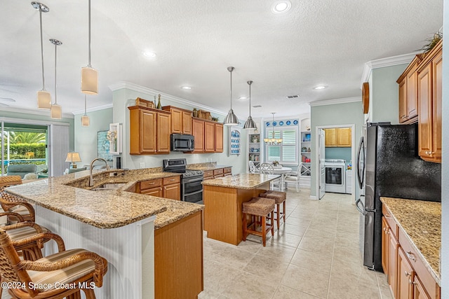 kitchen featuring a large island, appliances with stainless steel finishes, decorative light fixtures, and a kitchen breakfast bar