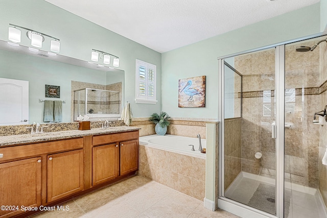 bathroom with vanity, tile patterned floors, a textured ceiling, and plus walk in shower