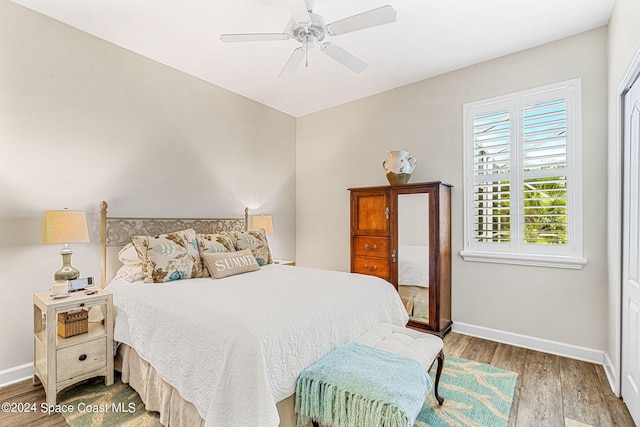 bedroom with hardwood / wood-style floors, a closet, and ceiling fan