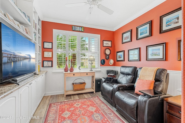 home theater room with crown molding, light wood-type flooring, and ceiling fan