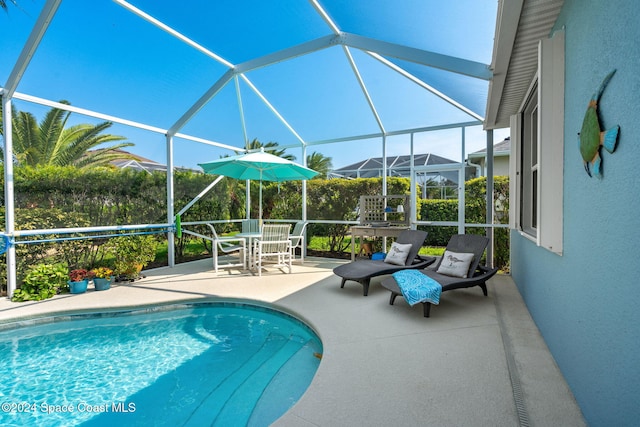 view of swimming pool with a patio and a lanai