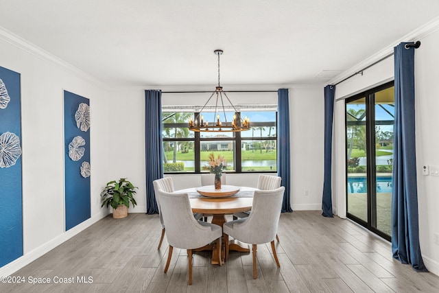 dining room with crown molding, a wealth of natural light, and light hardwood / wood-style flooring