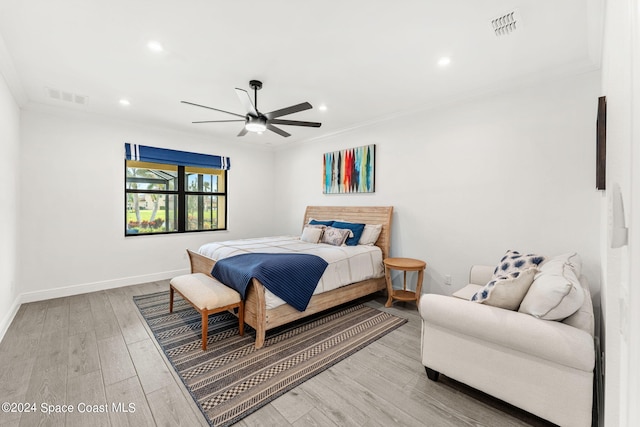 bedroom featuring light hardwood / wood-style floors, ceiling fan, and crown molding