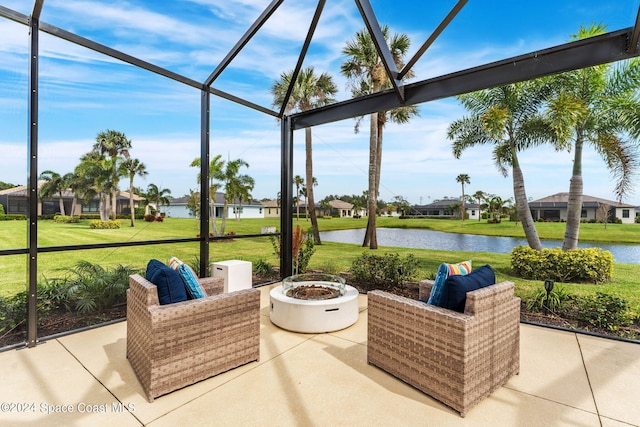 view of patio / terrace with glass enclosure, a water view, and an outdoor fire pit