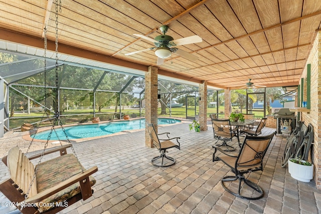 view of pool with ceiling fan, a patio, and a lanai