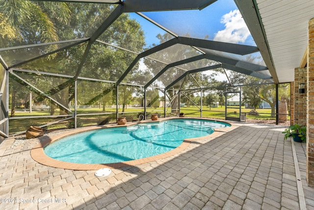 view of swimming pool featuring a patio, a lanai, and a yard