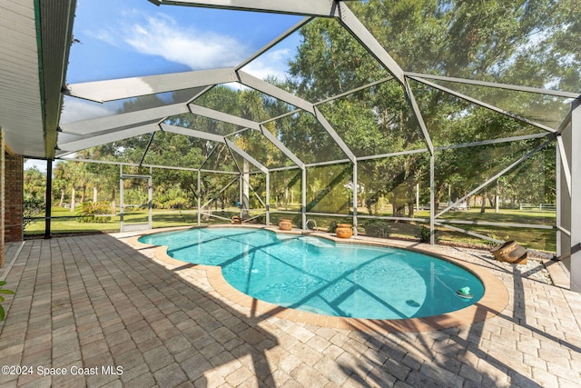 view of swimming pool featuring a patio and a lanai