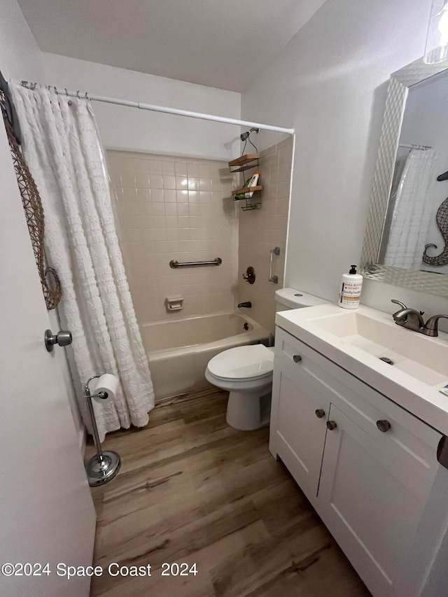 full bathroom featuring hardwood / wood-style flooring, shower / bath combination with curtain, toilet, and vanity