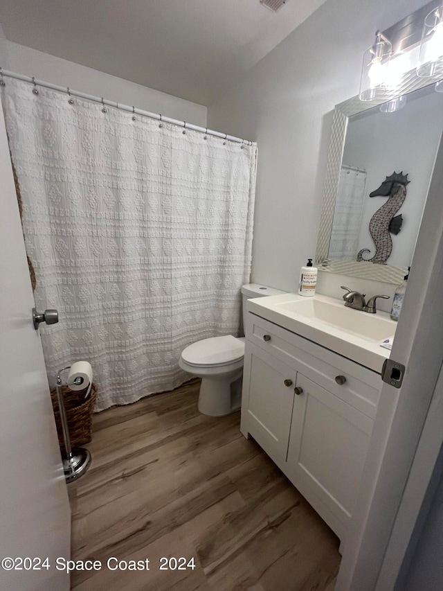 bathroom featuring wood-type flooring, vanity, and toilet