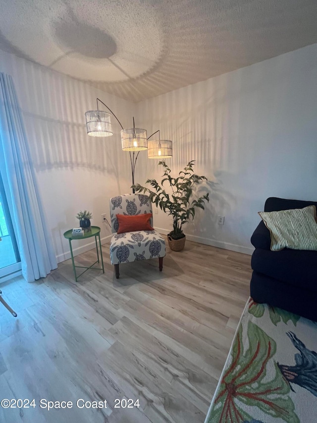 living area with hardwood / wood-style flooring and a textured ceiling