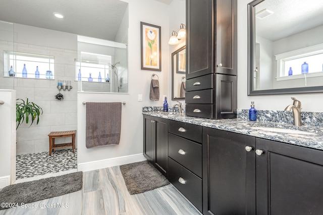 bathroom featuring vanity, a shower, a textured ceiling, and hardwood / wood-style floors