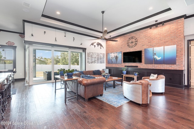 living room with ornamental molding, dark wood-type flooring, and a healthy amount of sunlight