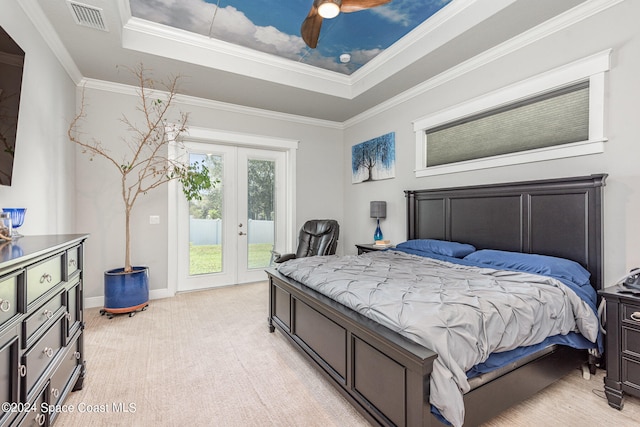 carpeted bedroom with ornamental molding, french doors, a tray ceiling, and access to outside