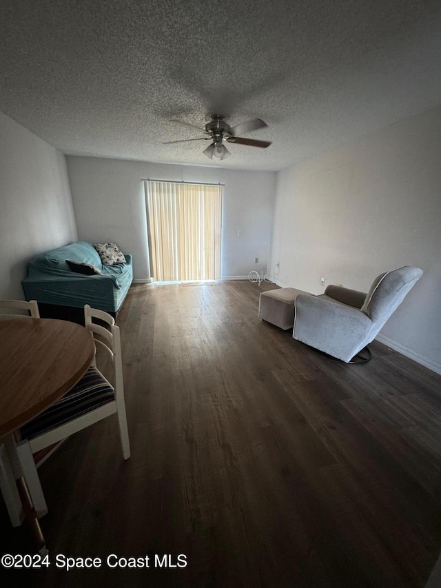 sitting room with a textured ceiling, ceiling fan, and dark hardwood / wood-style flooring