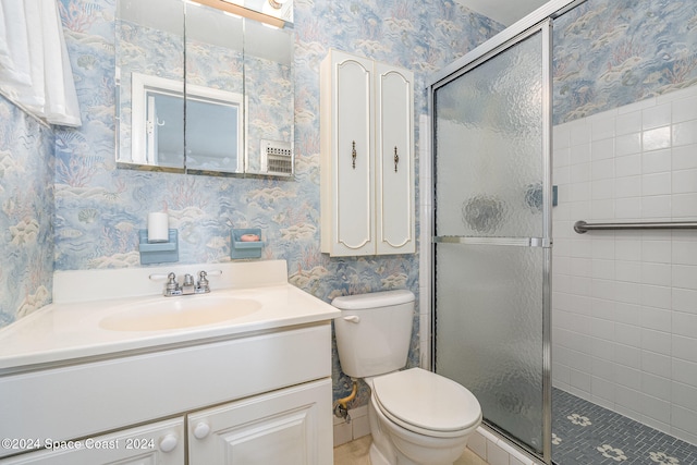 bathroom featuring vanity, a shower with shower door, and toilet