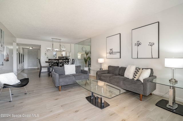 living room featuring a textured ceiling and light wood-type flooring