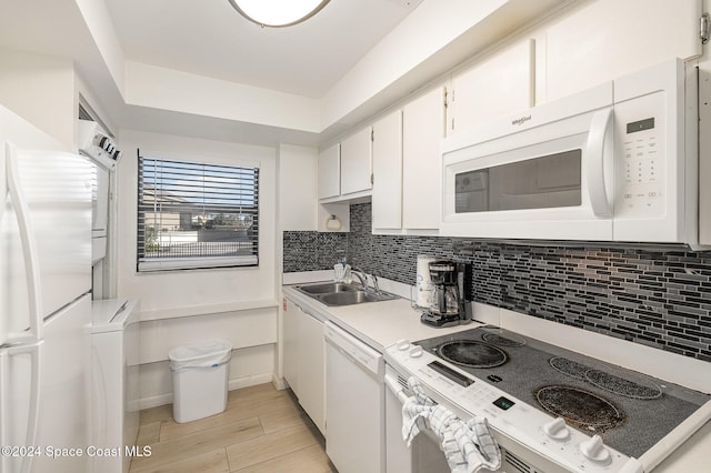 kitchen featuring tasteful backsplash, white cabinetry, light hardwood / wood-style flooring, sink, and white appliances